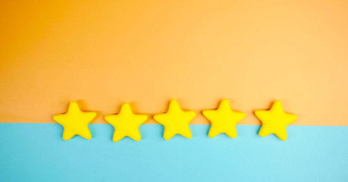 Bright yellow stars arranged on a vivid orange and blue background with copy space.