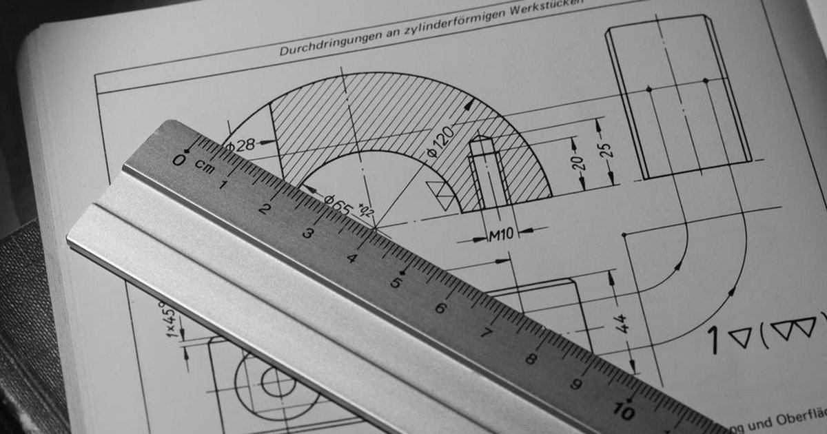 Black and white image of technical drawing with metal ruler, ideal for engineering concepts.