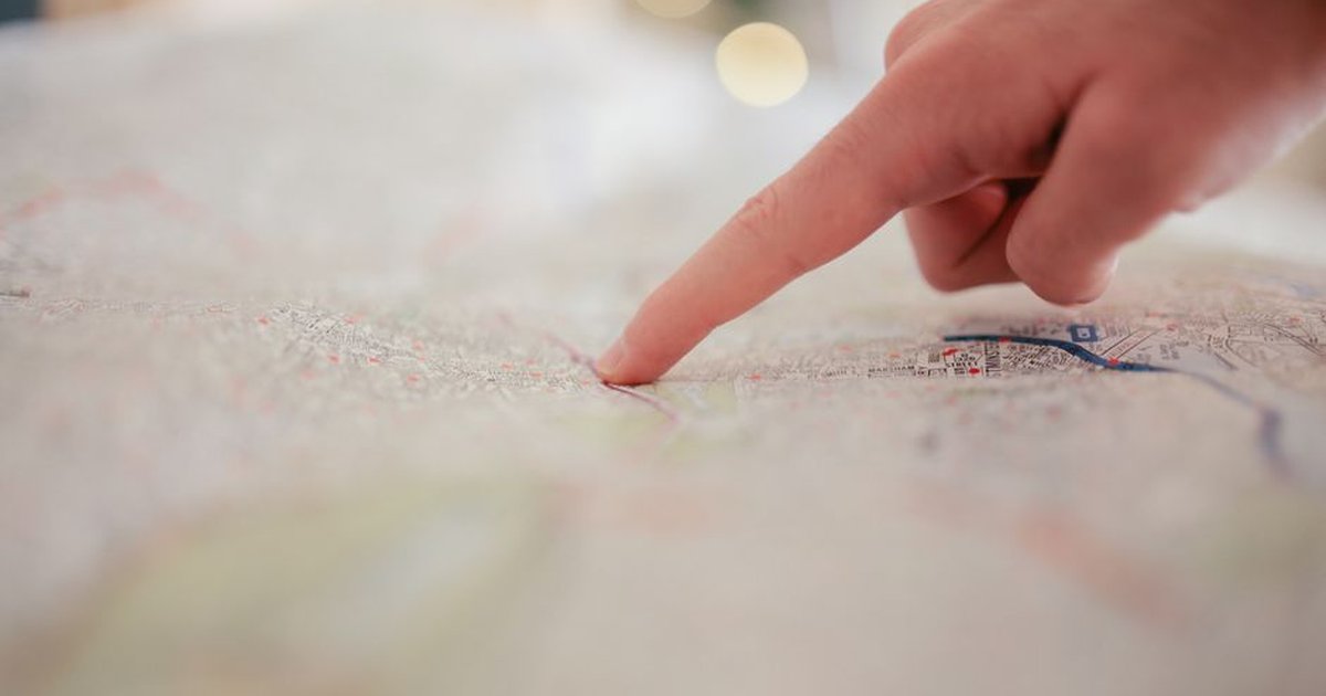 A hand pointing at a city map, highlighting direction and navigation planning.