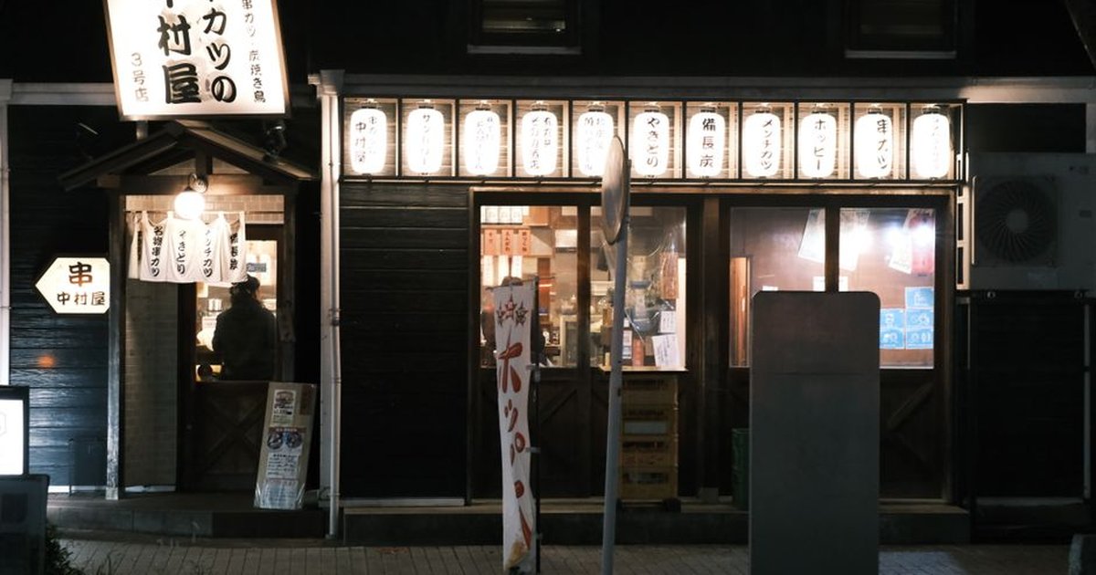 Illuminated restaurant in Toyohashi, Japan, captured at night. A cozy urban scene.