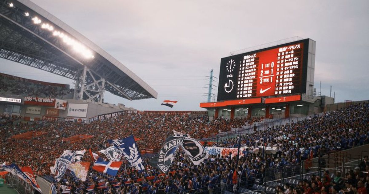 A vibrant soccer match with cheering fans at a packed stadium showcasing team spirit.