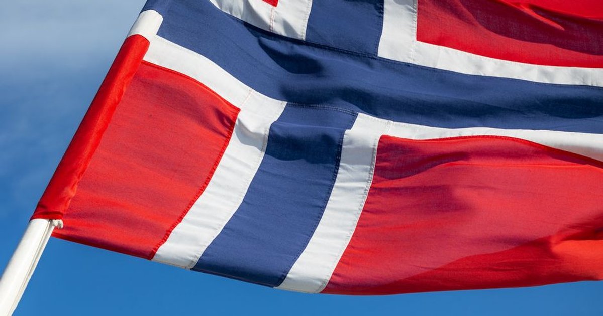 Close-up of Norwegian flag with vibrant red, white, and blue colors against a clear sky.
