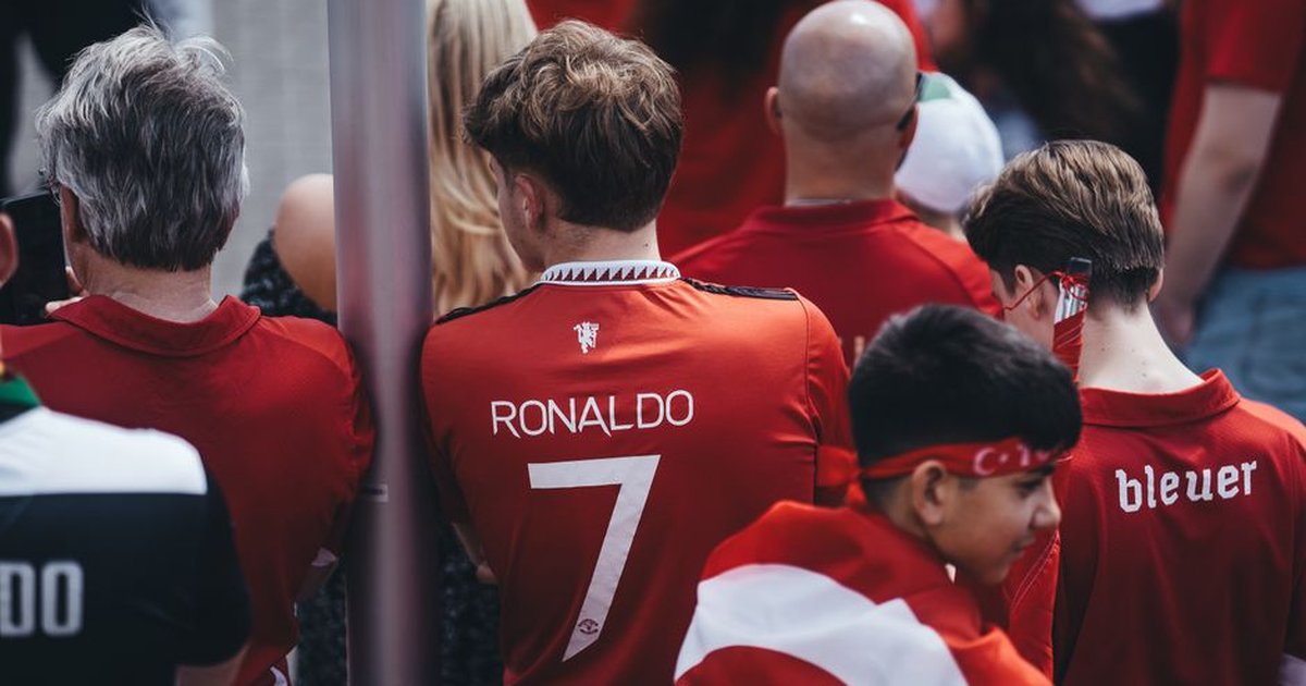 Football enthusiasts gather in team jerseys, celebrating their passion for the game outdoors.