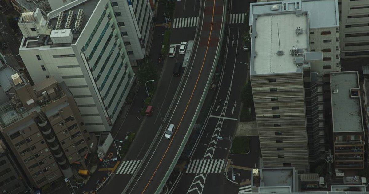 Drone view of residential area in modern city with transport on asphalt roads and multistory houses