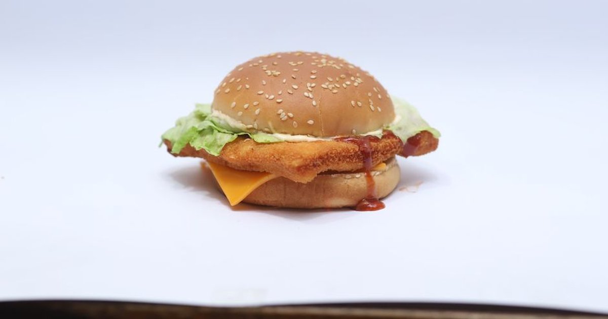 Mouthwatering cheeseburger with lettuce, cheese, and sauce on a sesame seed bun.