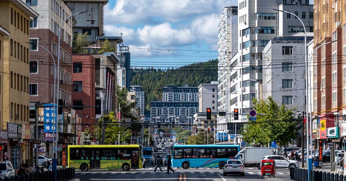 A bustling city street in Jilin Province, China, with buses, cars and pedestrians.